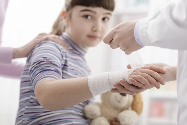 Bir kızın bileğinde bir bandaj sarma doktor — Stok fotoğraf