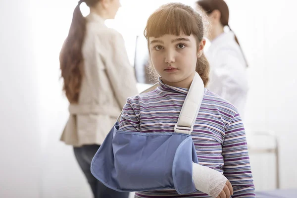 Kırık kol ve kol ayraç doktor ofisinde ile kız — Stok fotoğraf