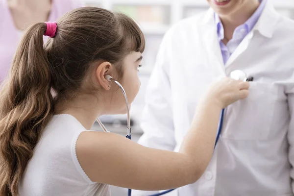 Vriendelijke Arts spelen met een jonge patiënt tijdens een bezoek — Stockfoto