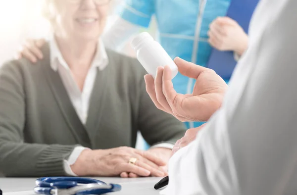 Professional doctor giving a prescription medicine to a senior p — Stock Photo, Image