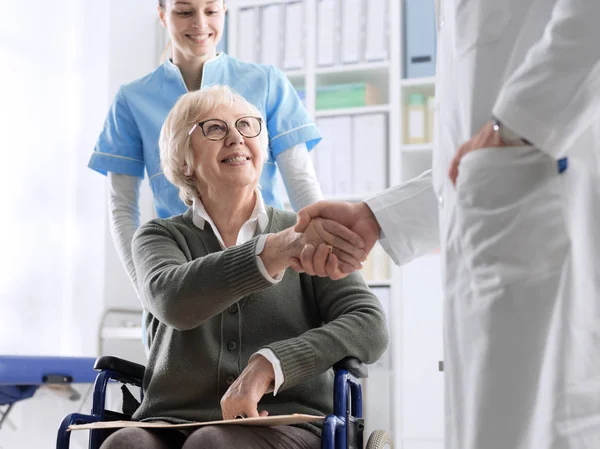 Dottore che dà una stretta di mano a un paziente anziano — Foto Stock