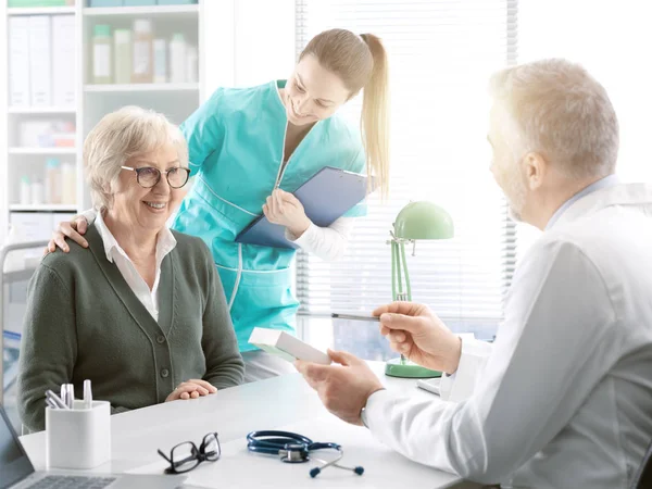 Médico profesional que da un medicamento recetado a una persona mayor p — Foto de Stock