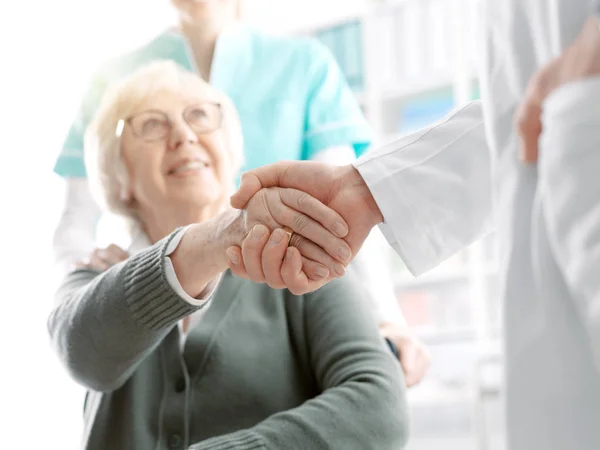 Médico dando um aperto de mão para um paciente sênior — Fotografia de Stock