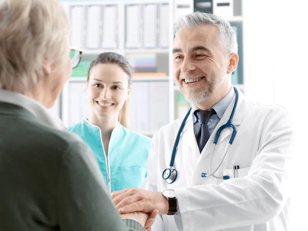 Professional doctor holding a senior patient's hands — Stock Photo, Image