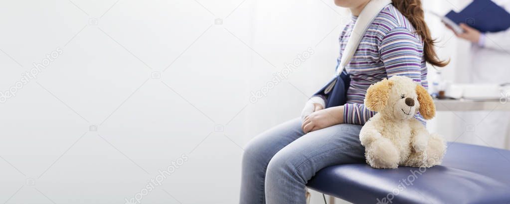 Girl with broken arm waiting in the doctor's office