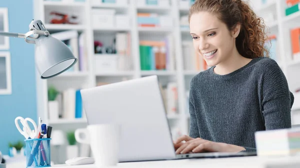 Menina estudante sorrindo se conectando com um laptop — Fotografia de Stock