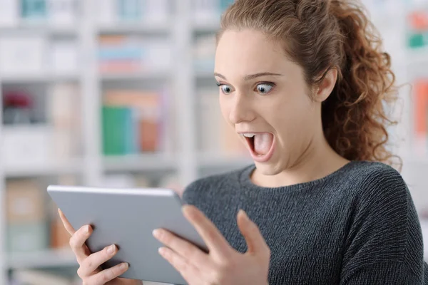 Sorprendida chica alegre conectar con su tableta —  Fotos de Stock