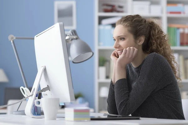 Ofiste bir bilgisayar kullanan genç kadın — Stok fotoğraf