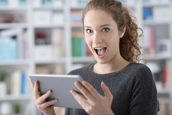 Menina alegre surpreso conectando com seu tablet — Fotografia de Stock