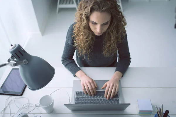 Молода жінка працює зі своїм ноутбуком — стокове фото