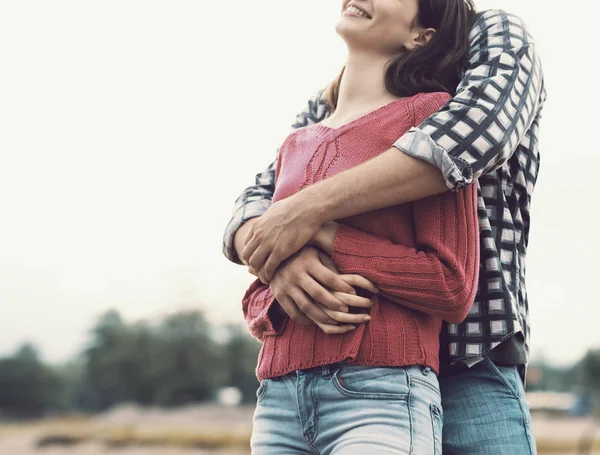 Feliz jovem casal abraçando e sorrindo — Fotografia de Stock