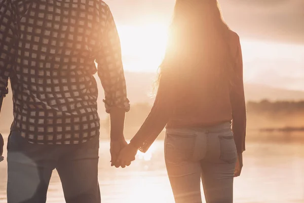 Jovem casal amoroso de mãos dadas ao pôr do sol — Fotografia de Stock