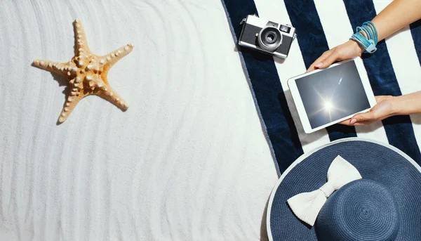 Donna che si rilassa sulla spiaggia e si collega con un tablet — Foto Stock