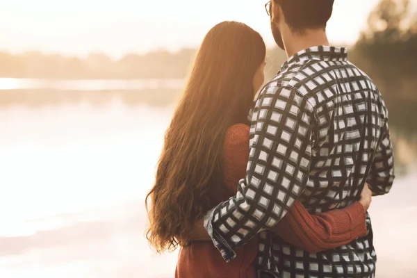 Liefdevolle paar knuffelen aan het meer — Stockfoto