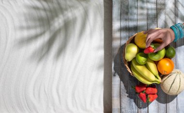 Sahilde yatan ve meyve yiyen kadın