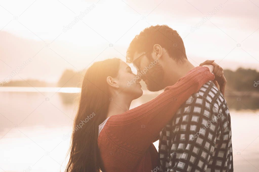 Sweet loving couple kissing at the lake