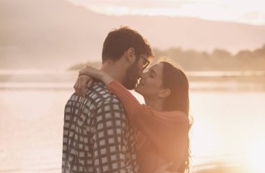 Genç romantik çift gün batımında öpüşme