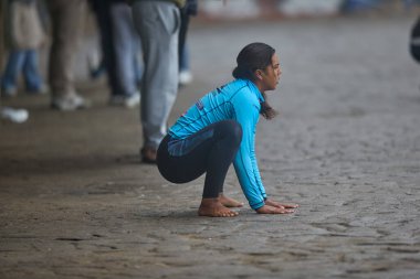 Fırtınadan önce odaklanın ve dengeyi sağlayın. Bir sörfçü kıyıya doğru uzanıyor, vücudu ve zihni La Herradura 'nın güçlü dalgalarına hazırlıyor. Chorrillos Peru.
