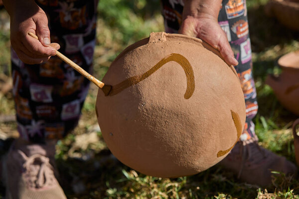 skillful hands bring life to the clay, tracing simple yet symbolic patterns onto the ollas de barro of Huancas. Each mark is a gesture of heritage, preserving centuries of artistry before the fire seals their timeless beauty.