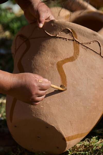 skillful hands bring life to the clay, tracing simple yet symbolic patterns onto the ollas de barro of Huancas. Each mark is a gesture of heritage, preserving centuries of artistry before the fire seals their timeless beauty.