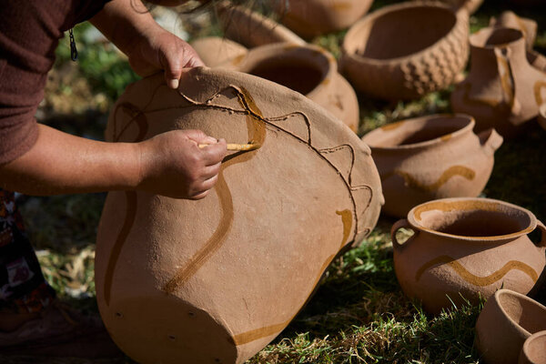skillful hands bring life to the clay, tracing simple yet symbolic patterns onto the ollas de barro of Huancas. Each mark is a gesture of heritage, preserving centuries of artistry before the fire seals their timeless beauty.