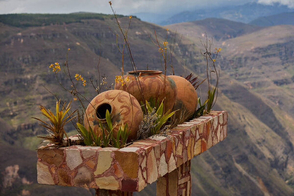 Traditional clay vessels at the Mirador of Huancas beautifully frame the breathtaking canyon landscape, blending culture with nature.