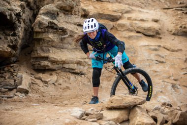 Yokuş aşağı bir MTB binicisi, arka planda Pasifik Okyanusu ve Lima şehrinin görkemli manzarasıyla El Morro Solar 'ın engebeli hatlarını oyuyor..