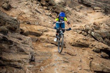 Yokuş aşağı bir MTB binicisi, arka planda Pasifik Okyanusu ve Lima şehrinin görkemli manzarasıyla El Morro Solar 'ın engebeli hatlarını oyuyor..