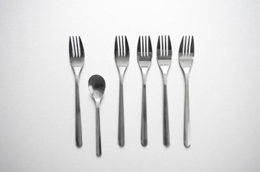 satır gri arka plan rekabet kavramsal fotoğraf gıda veya iş arka plan üzerinde benzersiz küçük kaşık ile gümüş metal çatal