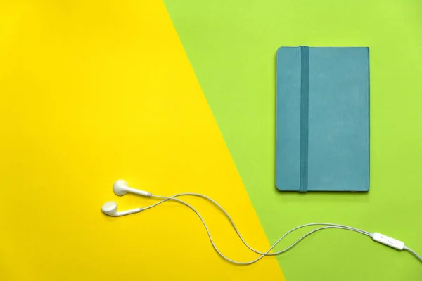 Libro de notas azul con auriculares blancos en verde amarillo col educación —  Fotos de Stock