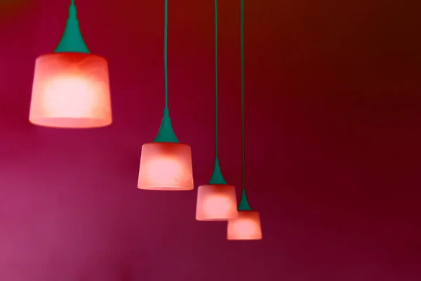 row of hanging lamp in red green glowing neon color