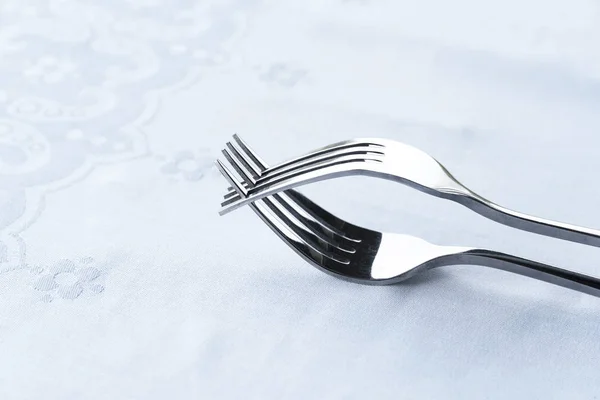 Silver stainless steel two interaction fork on white tablecloth — Stock Photo, Image