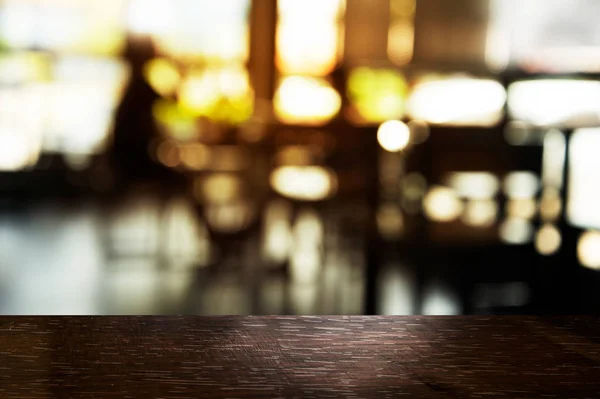 Parte superior de madera de mesa negra con luz borrosa en el bar o restaurante ingenio —  Fotos de Stock