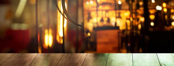 暗い夜のパーティーでぼかしバーやパブで木製のテーブルの上オレンジライトシティインテリアバナーの背景 — ストック写真