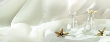 Kahverengi organik tohum çiçekli cam bilim şişesi. Beyaz bej bej renkli afiş. Sağlık konsepti.