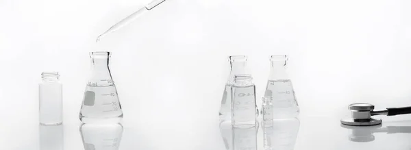 医院实验室白底医用听诊器科学瓶和滴水器中的水 — 图库照片