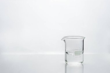 Beyaz tıbbi laboratuvar geçmişi olan cam şişedeki temiz su. 