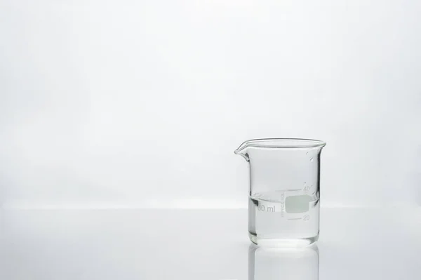 clean water in glass beaker with white medical health laboratory background