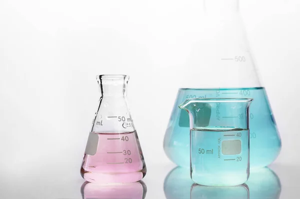 Rosa Und Blaue Lösung Becher Und Kolben Weißem Chemielabor Hintergrund — Stockfoto