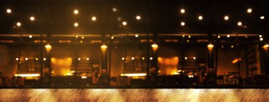 Doğal ahşap masanın tepesinde soyut bulanıklık çubuğu ya da karanlık gece afişi ile ışık yansıması olan bir masa.