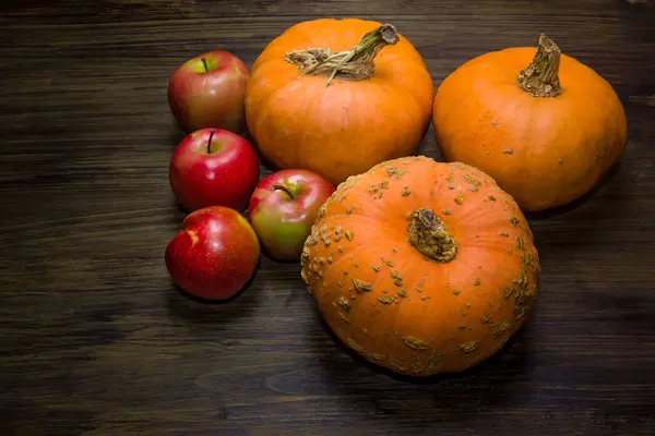 Kabak ve elma. Elma ve ahşap bir masa üzerinde kabaklar sonbaharda hasat. Kırmızı elma.