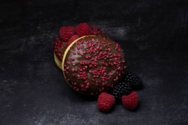 Lezzetli Çörekler ya da Siyah Arkaplanda Taze Böğürtlenli Berlinliler. Kahvaltı ya da Reçelli ve Meyveli Atıştırmalık..