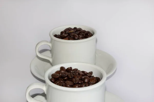 Geröstete Kaffeebohnen Zwei Kaffeetassen Auf Weißem Hintergrund — Stockfoto