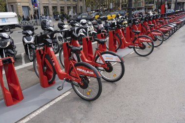 Barselona, Katalonya, İspanya - 3 Ekim 2020. Bir bisiklet istasyonunda kiralanan kırmızı bisikletler. Çevre dostu şehir içinde seyahat ve dolaşım için sürdürülebilir kavram..