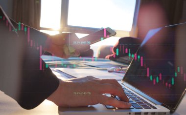 Fibonacci göstergesi olan dizüstü bilgisayar ve hisse senedi grafiği kullanarak çifte maruz kalan iş adamı