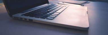 Web için panoramik pankart, klavyede güneş ışığı parlayan dizüstü bilgisayarın ayrıntılı görünümü