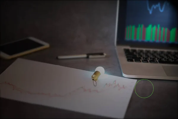 Yeni iş finansal analizi fikri veya borsa grafik analizi konsepti, akıllı telefon ekranında bulanık ampul ışığı fikri, bulanık kalem ve beyaz kağıt üzerinde borsa grafiği