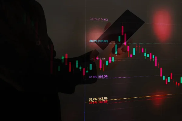 Hisse senedi grafiğini Fibonacci göstergesine göre analiz eden işadamı, hisse senedi alım-satımı için tablet tutan işadamı, çift taraflı hisse senedi grafiği ve kişi, borsa grafiği kavramını analiz eden işadamı veya borsa simsarı