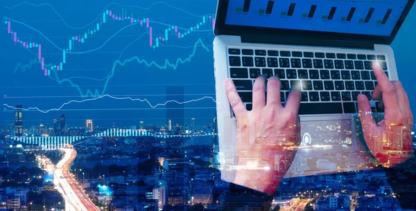 Grafik analizi konsepti, iş adamı veya borsa grafik verilerini analiz eden borsa grafik şeması, arka planda şehir manzarası gece görüşü