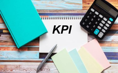 Hesap makinesi, çıkartma ve defin defteriyle KPI metni olan defter